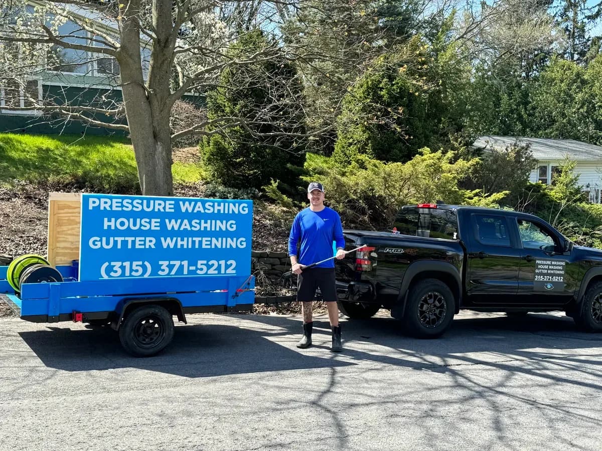 Oliver standing next to his original pressure washing trailer and truck during Six Mile's first year in business