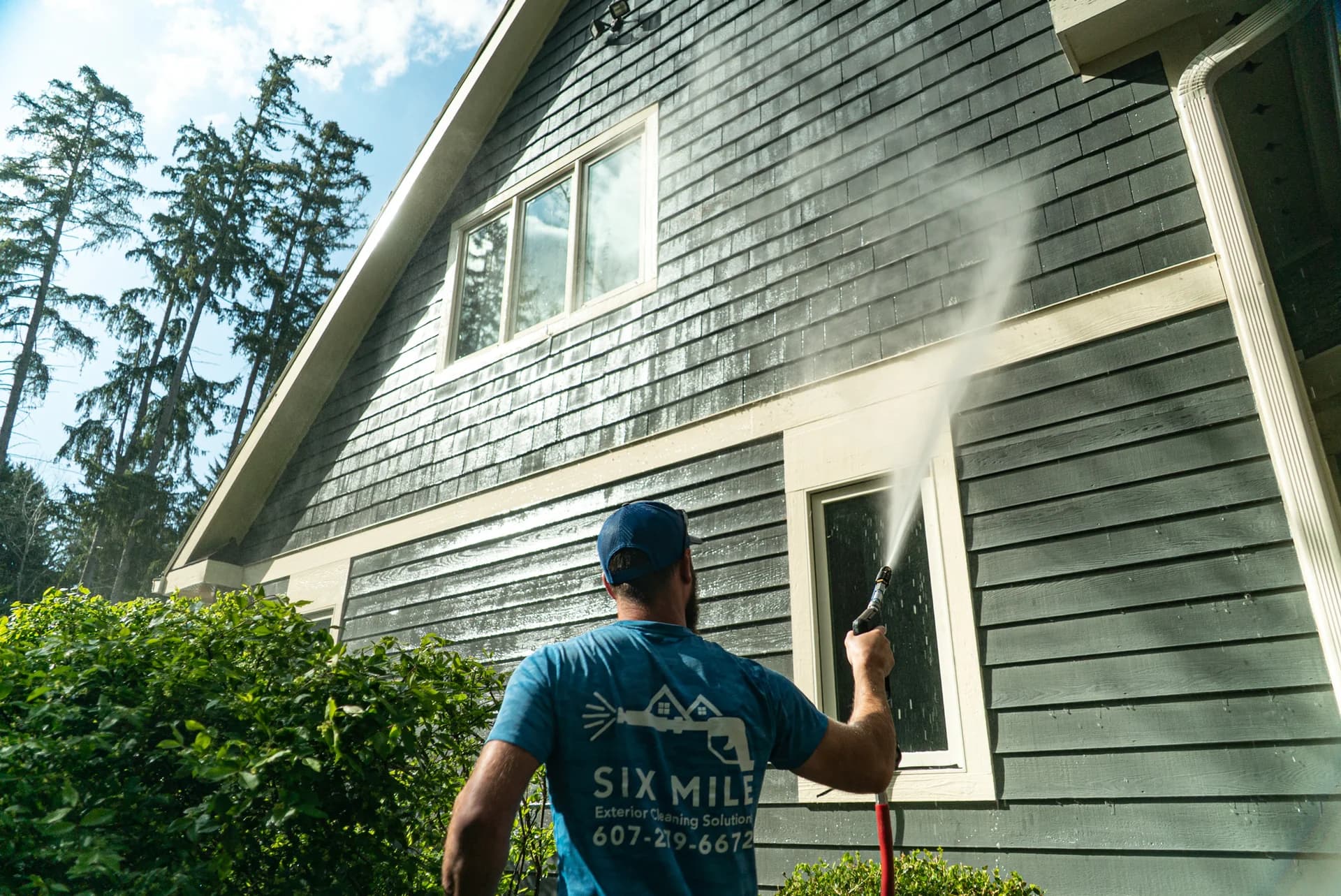 Six Mile technician soft washing algae and dirt from home siding