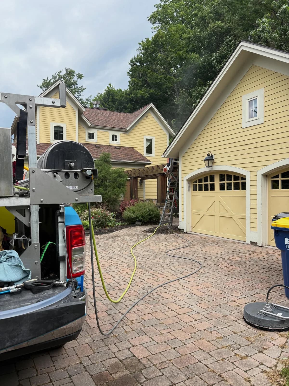 Driveway paver restoration job in progress at an East Shore home on Cayuga Lake, equipment staged before power washing