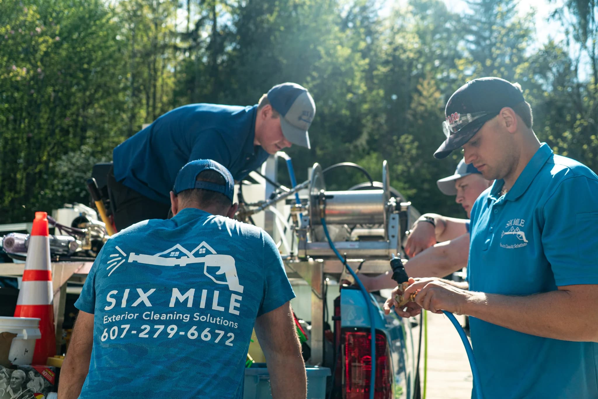 Six Mile crew setting up soft-washing equipment on a job site